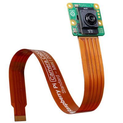 Raspberry Pi AI-camera module die rechtop staat, met de oranje lintkabel die sierlijk door de lucht buigt.